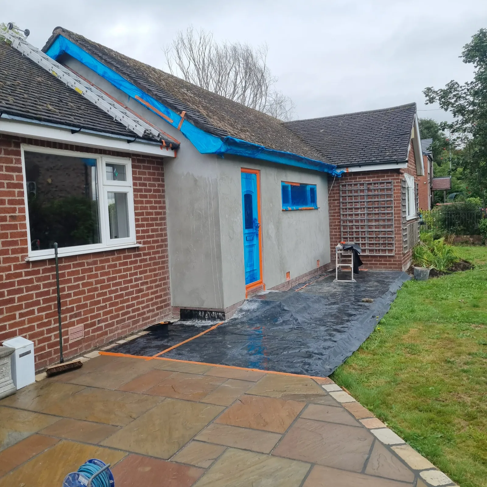 Bungalow side extension at grey basecoat stage with openings masked, Southport