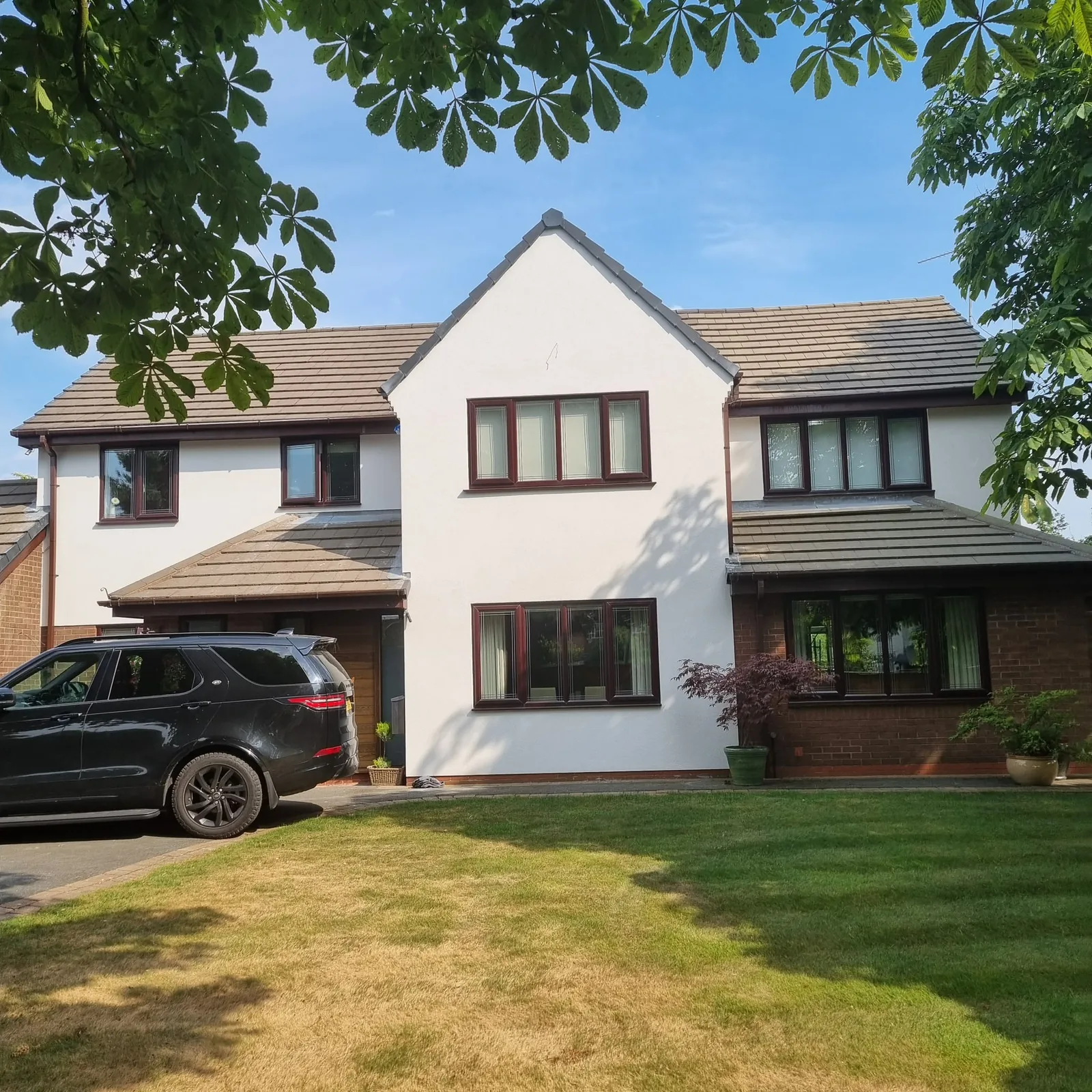 The same Formby house finished in white silicone render with the brick kept below