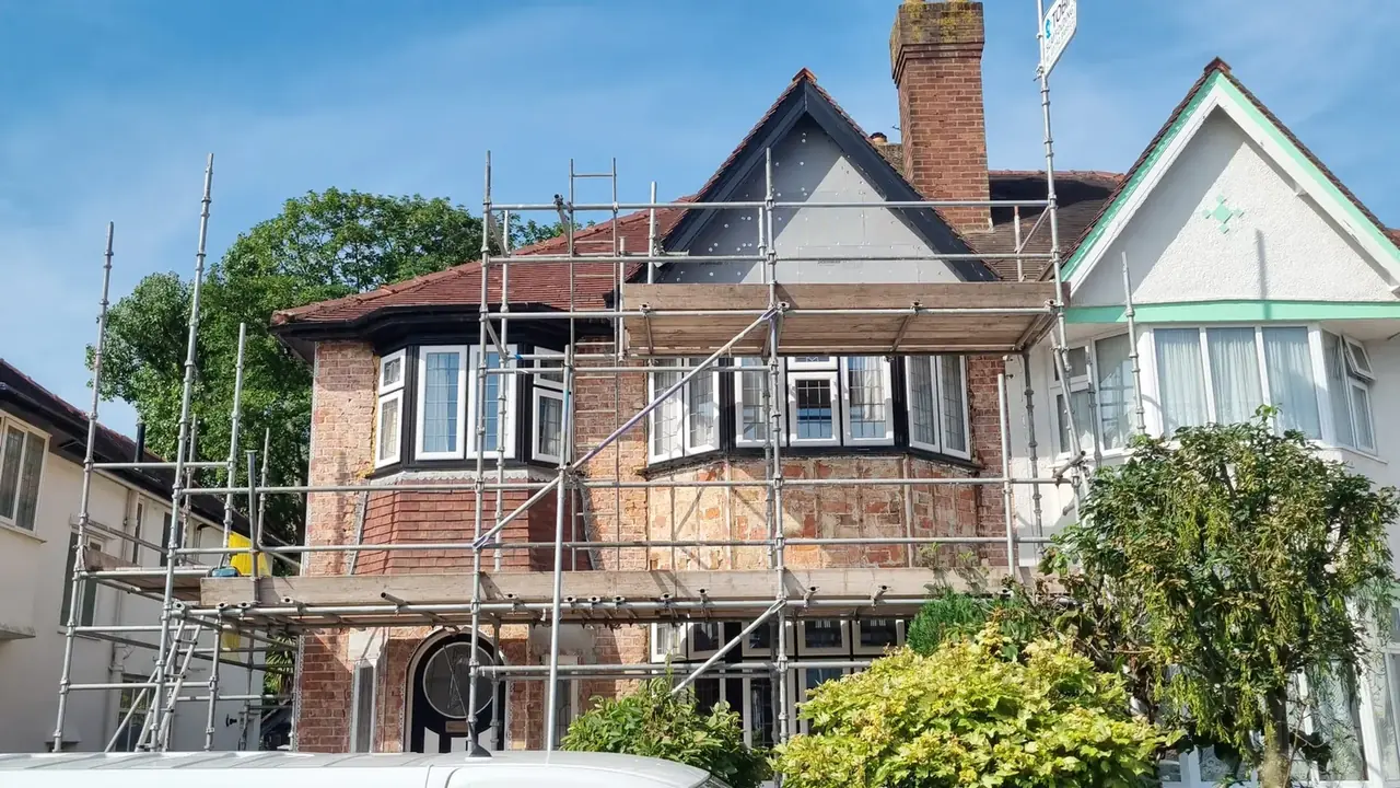 Failed old render stripped back to brick with the scaffold up