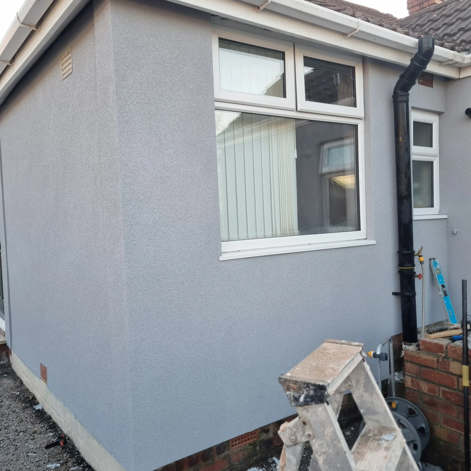 Grey through-colour silicone render on a clean corner detail in Southport
