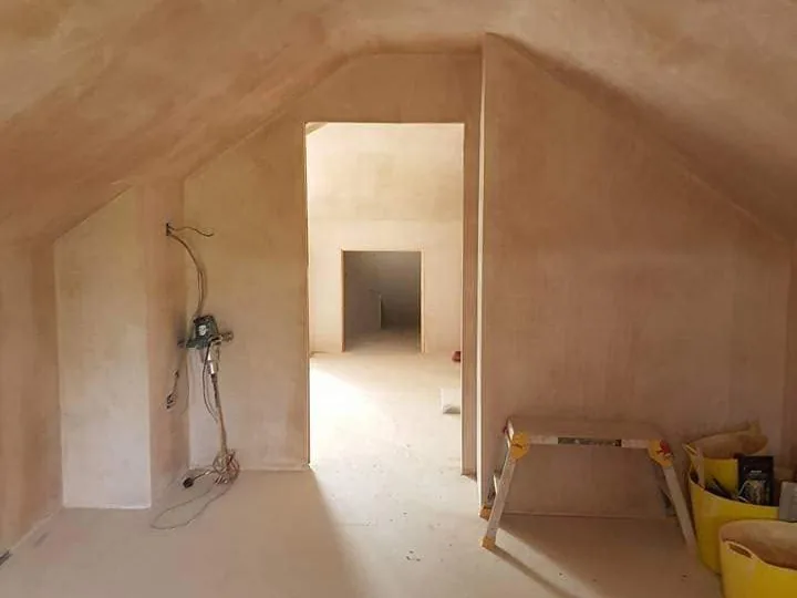 Loft conversion room freshly skimmed, apex ceiling running into knee walls with the opening through to the second room, Southport