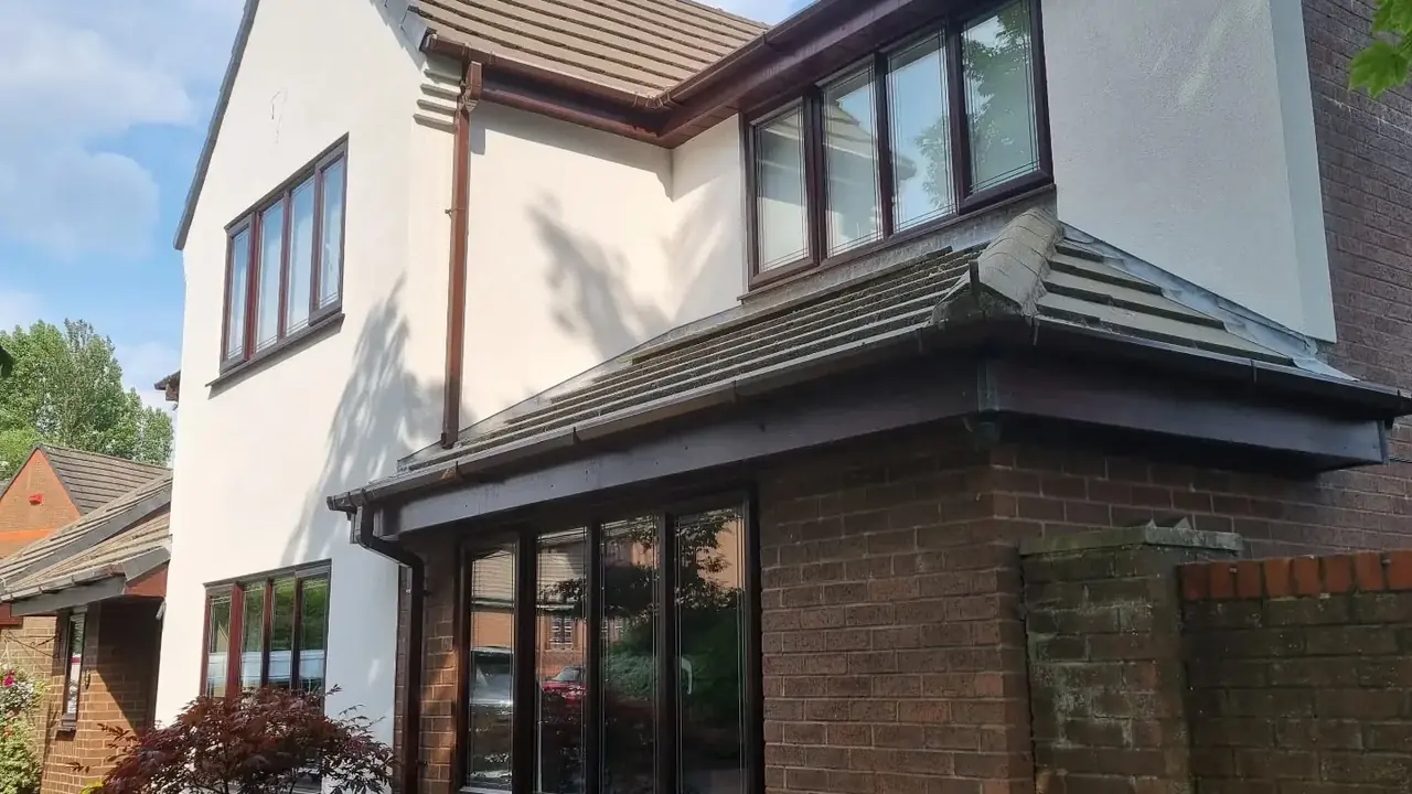 Modern detached house in white render over a brick plinth