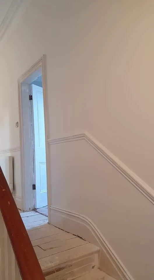 Plastered stairwell with dado rail and cornice finished in white, Southport
