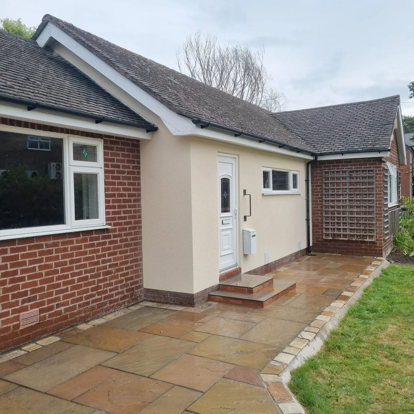 Bungalow side extension finished in cream render with a new door, Southport
