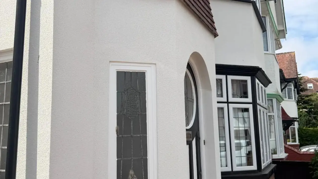 Silicone render worked around a projecting bay, tiled canopy and arched front door