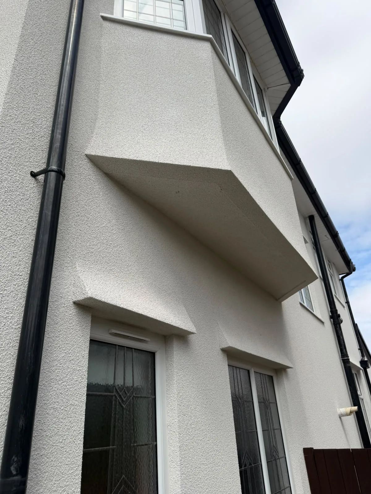 Silicone render wrapping a projecting bay and canopy on a Southport property