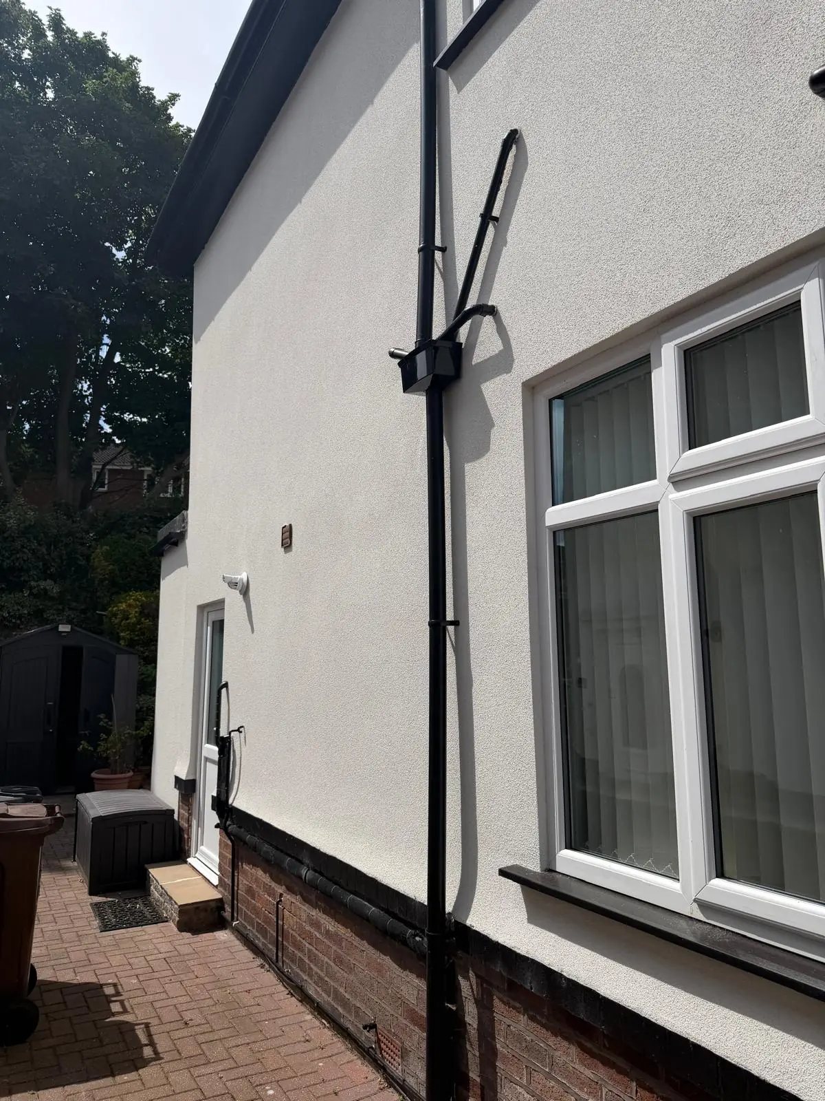 External rendering finished around downpipes and windows on a Southport side elevation