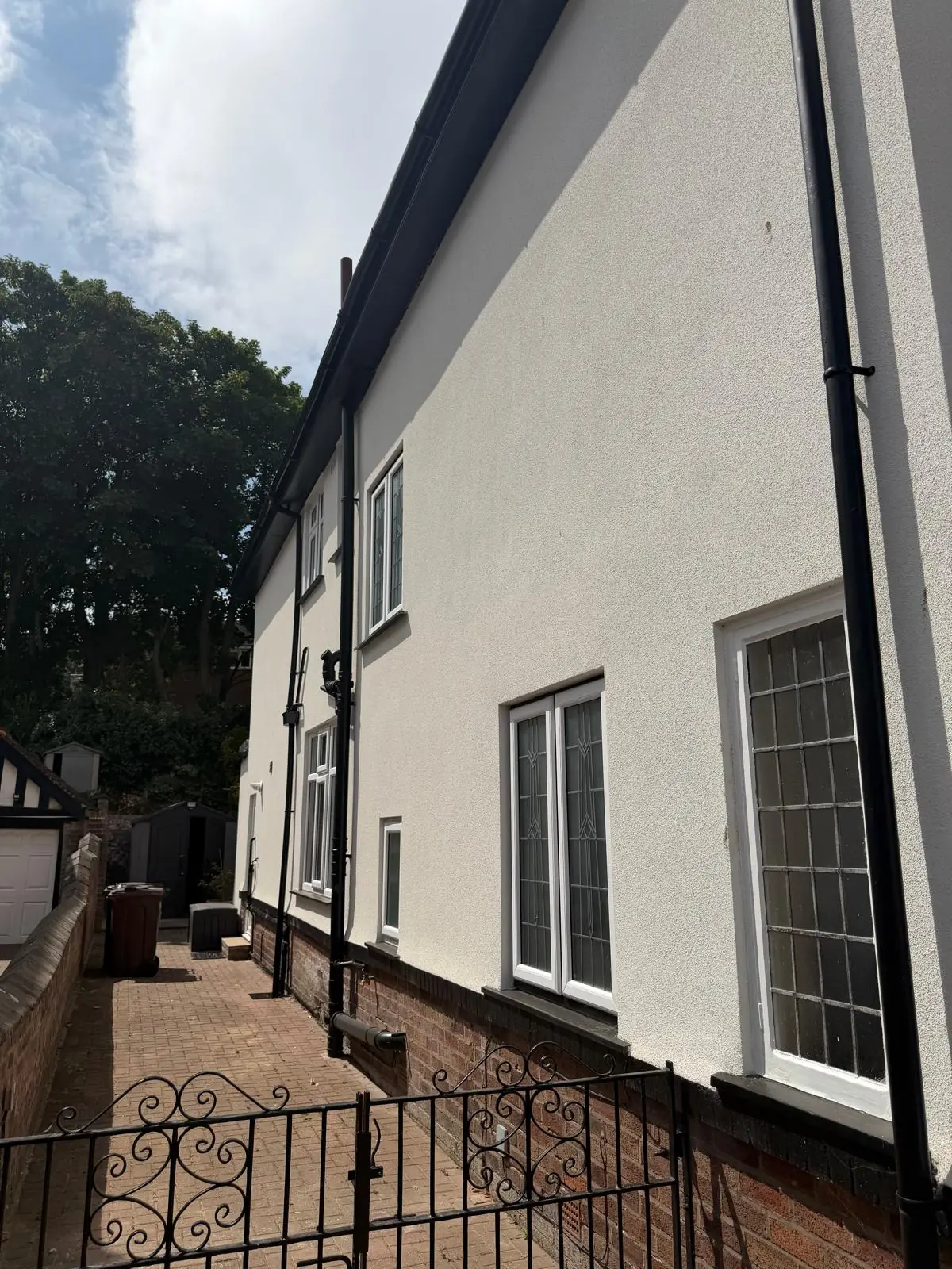 Silicone render on a full two-storey side elevation beside a gated side path in Southport