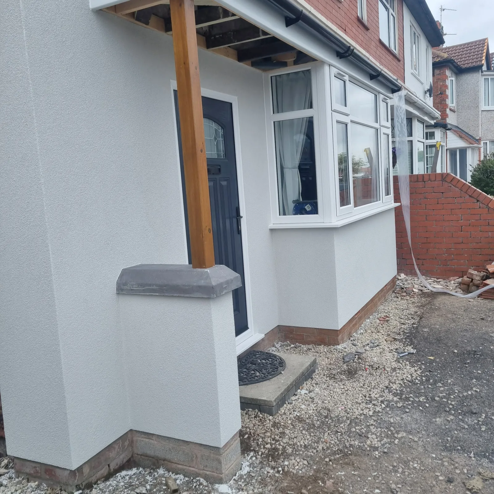 Finished white render on a front bay, porch and brick pier in Southport
